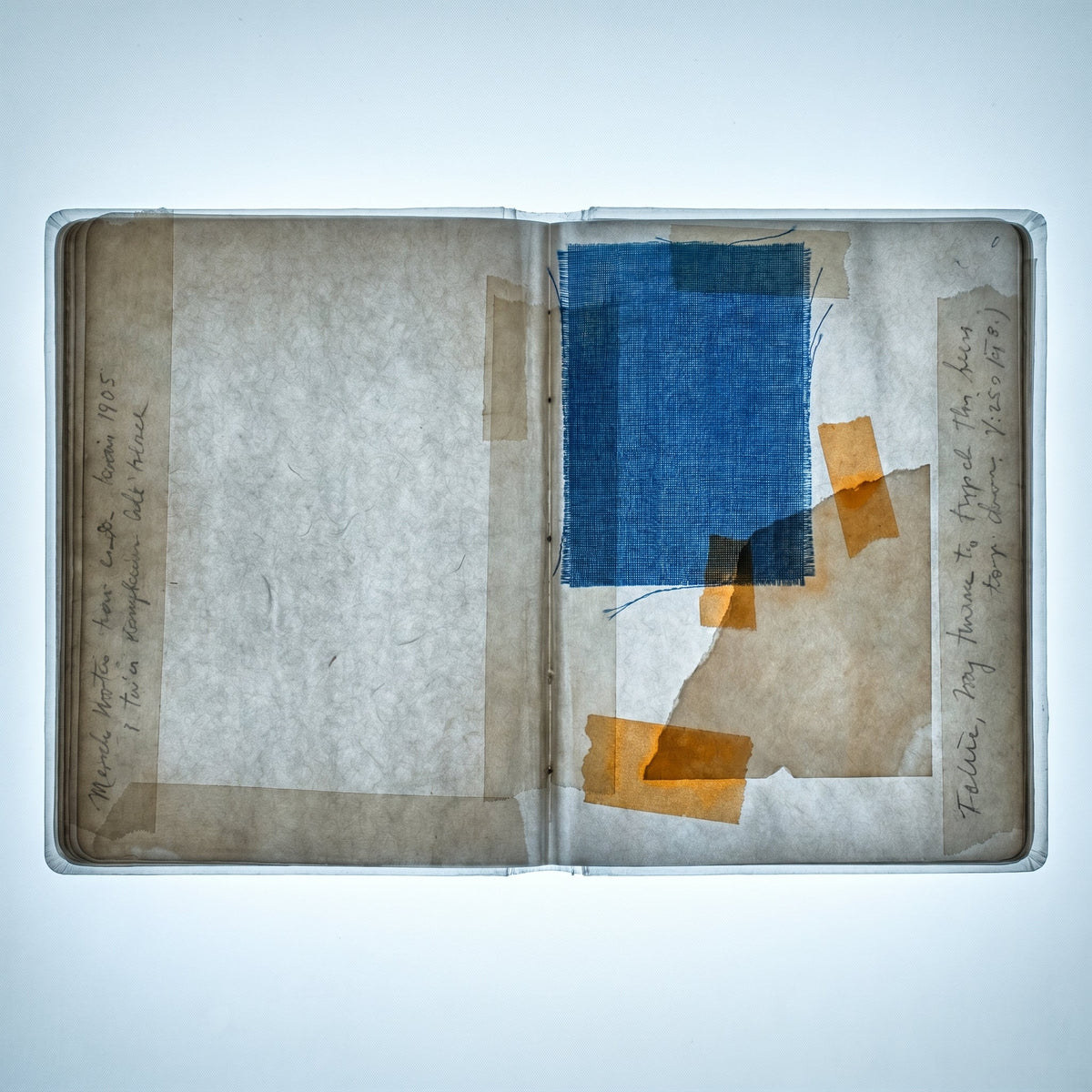 X-ray close-up of an open notebook with a fabric swatch glued to the page on an illuminated lightbox
